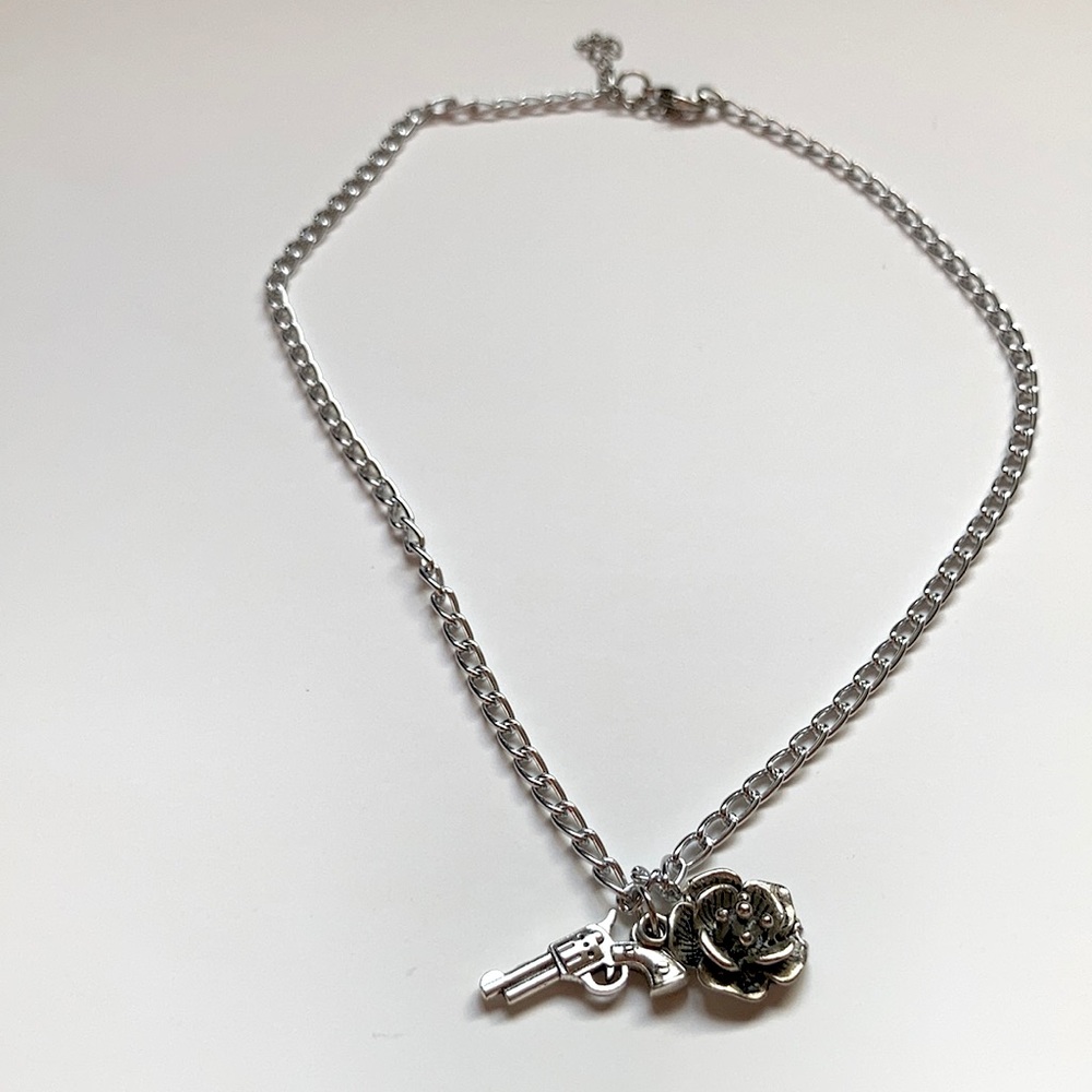 a medium sized chain with a rose gun charm